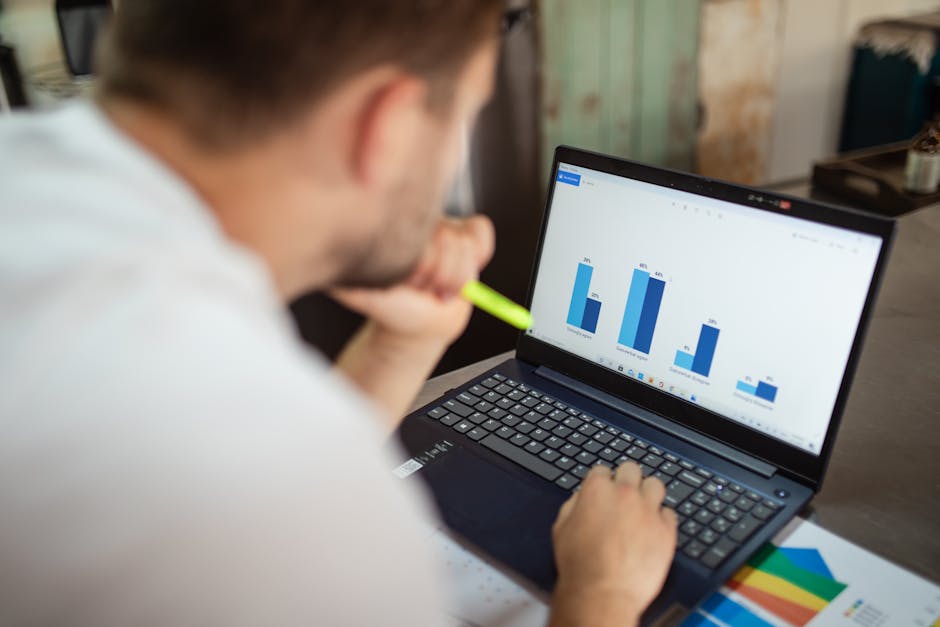 Security analyst reviewing log files on a laptop in a clean workstation