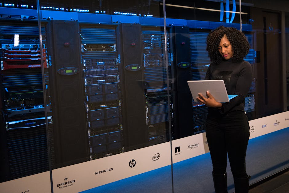 IT technician monitoring a server rack while reviewing security alerts